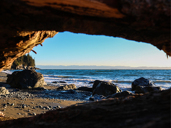 an ocean lookout captured through some rocks on a beach on Vancouver Island
